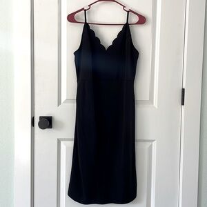 Black mini dress with scallop neckline.
